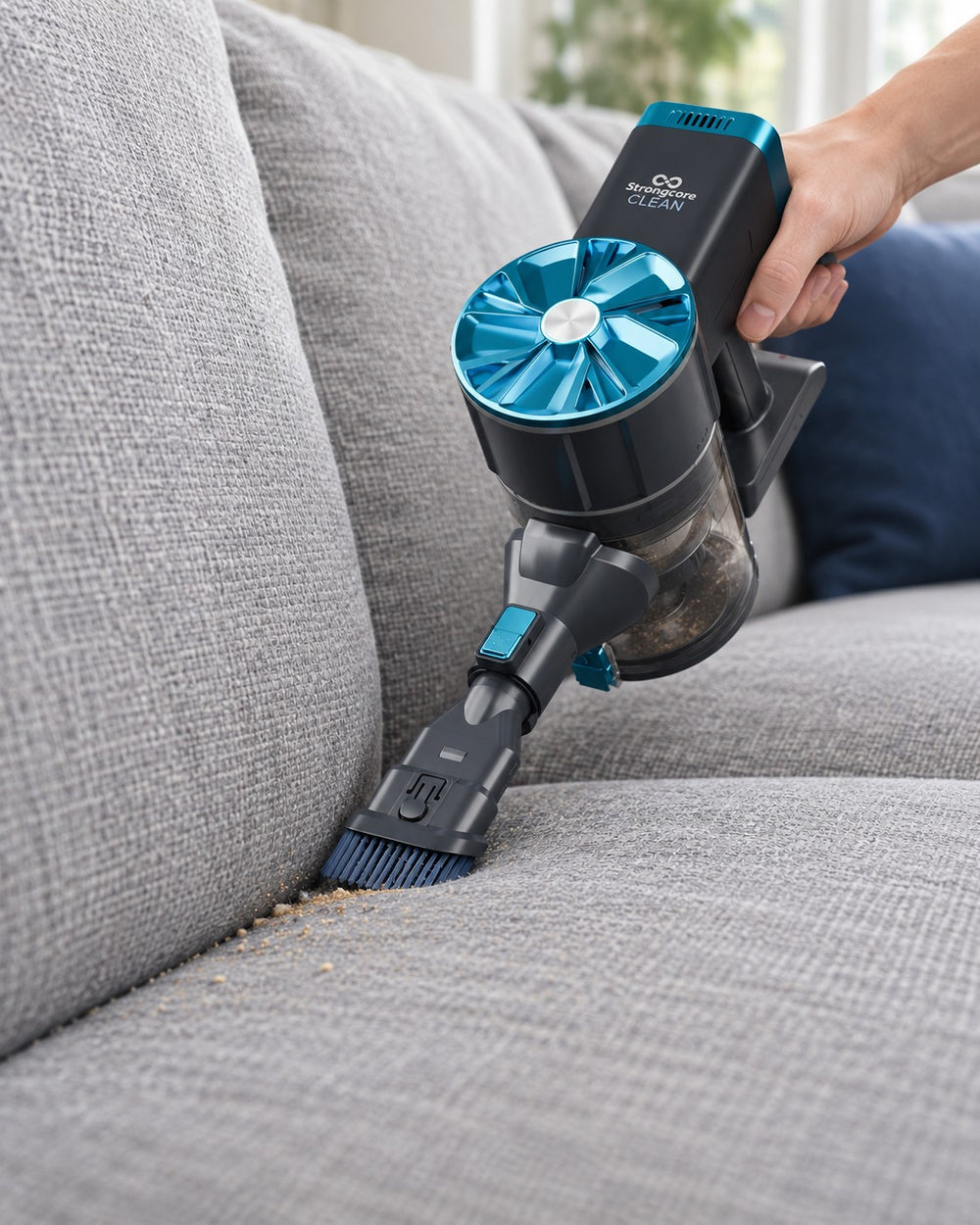 CLEAN in handheld mode using its 2-in-1 brush along a fabric sofa seam.