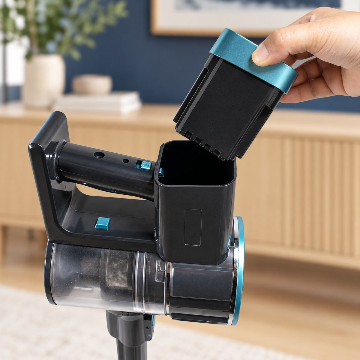 A hand lifting CLEAN's removable battery out of its matching upper socket.
